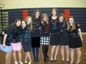 Group of smiling students in custom t-shirts.